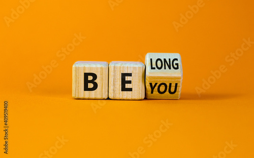 Be you, belong symbol. Turned a cube and changed words 'be you' to 'belong'. Beautiful orange background. Business, belonging and be you belong concept. Copy space.