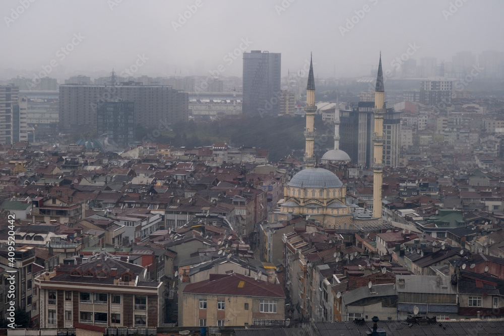 Zooming in Bayrampasa district of Istanbul and mosque, towers, buildings around in the rain