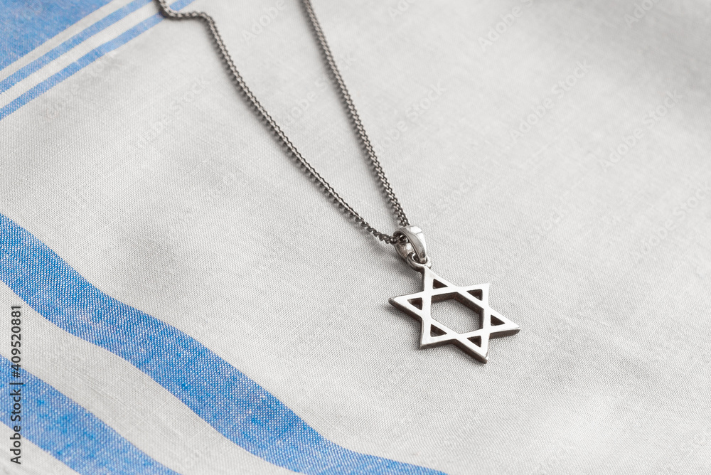 Star of David necklace, Magen David, on white-blue fabric.