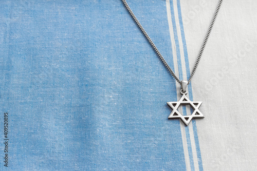 Obraz na płótnie Star of David necklace, Magen David, on white-blue fabric. w salonie