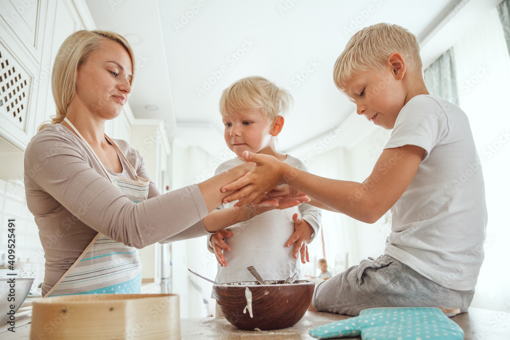 Mom with two sons cooking holiday pie in the kitchen. Casual life Mom with two sons cooking holiday pie in the kitchen. Casual life