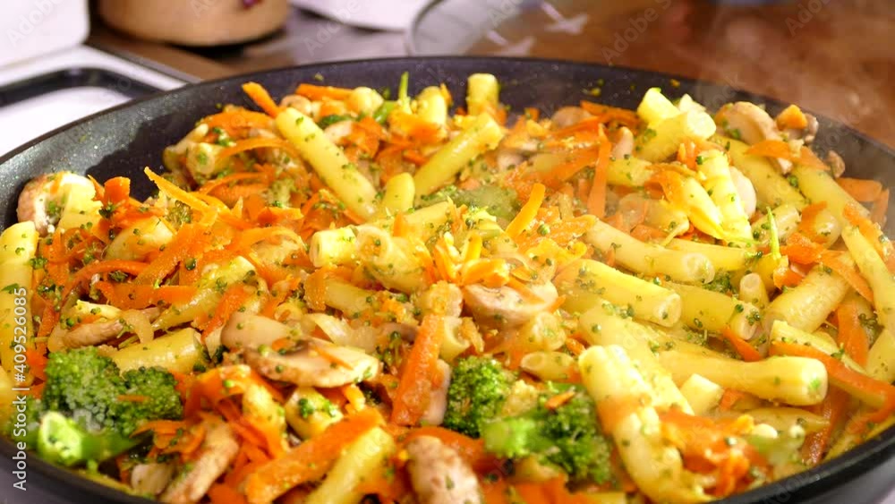 Cook vegetable stew in a pan with mushrooms and asparagus. Vegetarian food. Lunch in the kitchen. Cook vegetable stew in a pan with mushrooms and asparagus. Vegetarian food. Lunch in the kitchen.