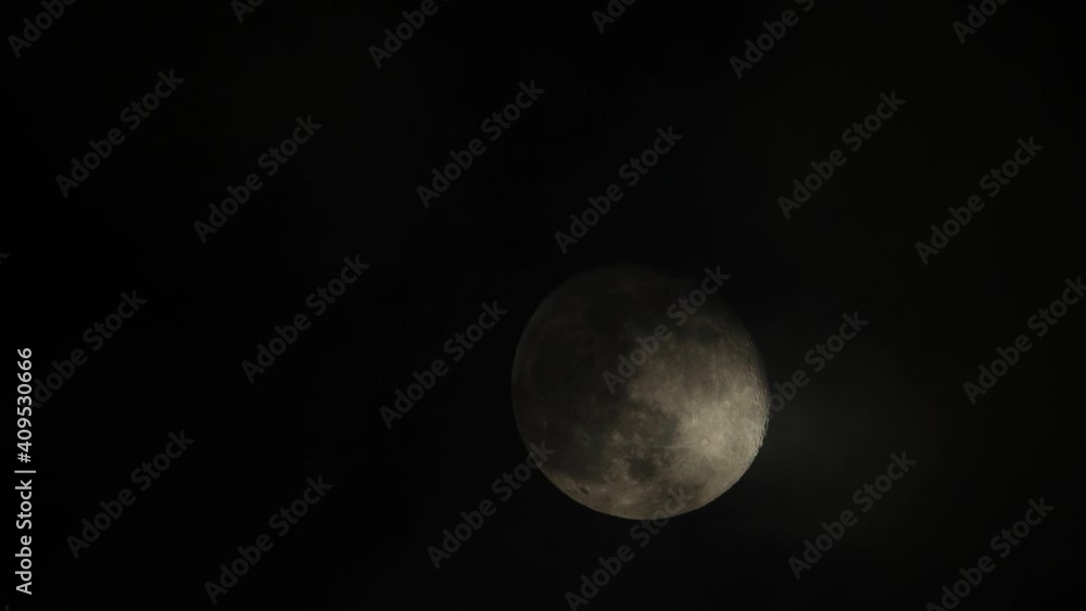 Close-up of a bright full moon in a black sky with wispy clouds passing in front giving the effect of moving shadows on the moon’s surface. Close-up of a bright full moon in a black sky with wispy clouds passing in front giving the effect of moving shadows on the moon’s surface.