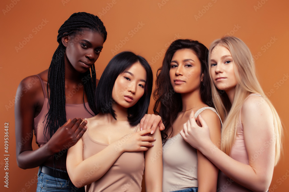 Obraz premium young pretty asian, caucasian, afro woman posing cheerful together on brown background, lifestyle diverse nationality people concept