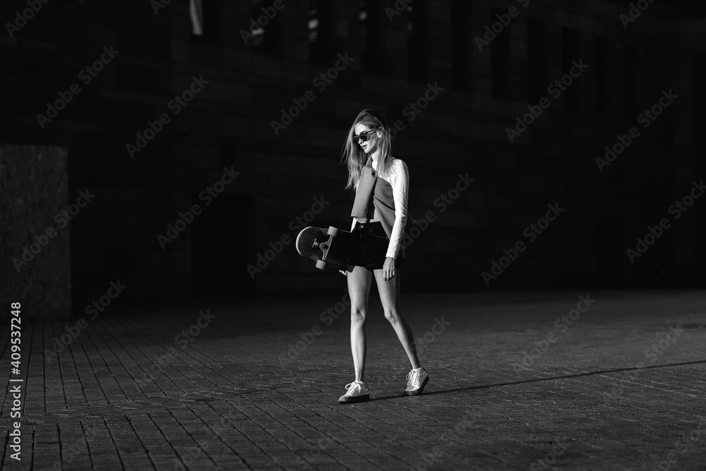 Contrasting black and white portrait of a woman with a skate in his hands. Contrasting black and white portrait of a woman with a skate in his hands.
