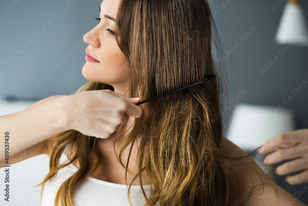Fototapeta premium Woman Using Comb Combing Long Hair
