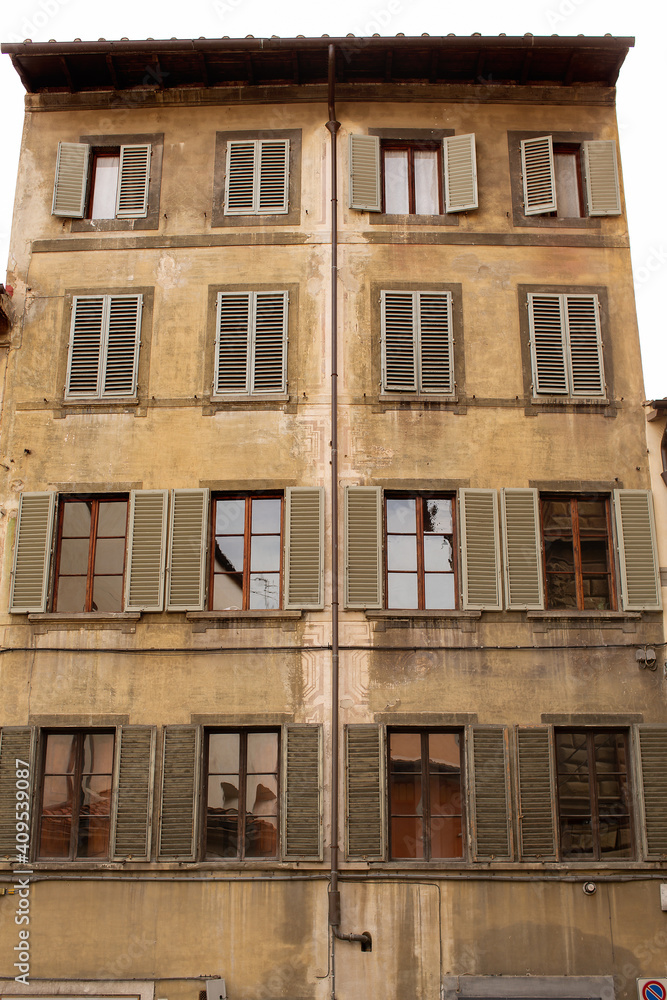 Five storey apartment building with shutters on the windows