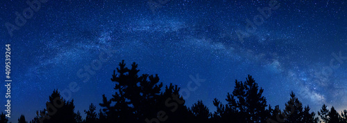 Milky Way landscape panorama. Panoramic view of the arch of the Milky Way on a starry dark night. Connect to nature under the stars in magical blue sky. Universe, dreams and real outdoor adventure.