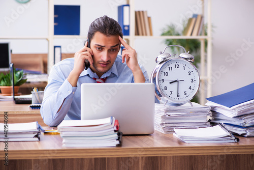 Young male employee unhappy with excessive work in time manageme