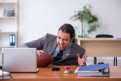 Young male employee with rugby ball in the office © Elnur