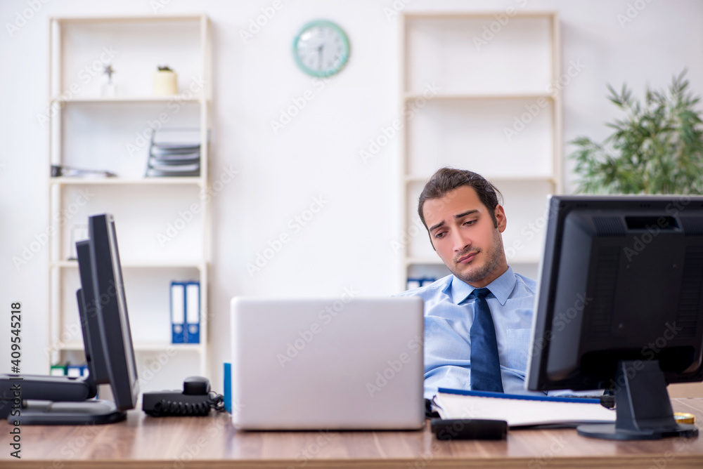 Young male employee unhappy with excessive work Young male employee unhappy with excessive work