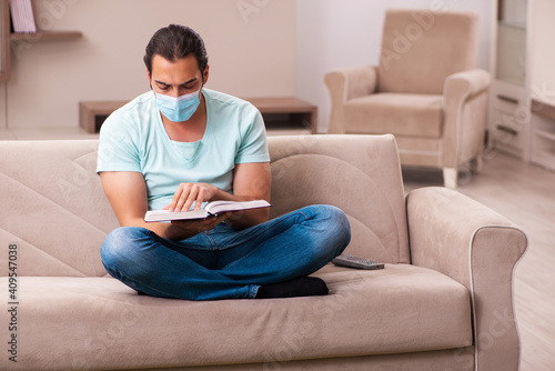 Young male student studying at home during pandemic