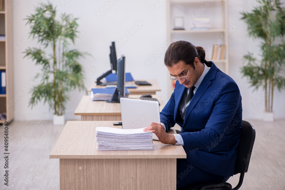 Young male employee working in the office Young male employee working in the office