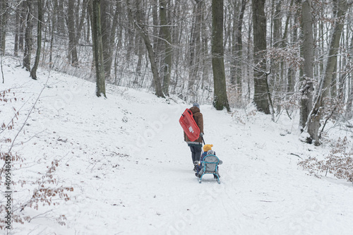 mother pulling kid on sledge