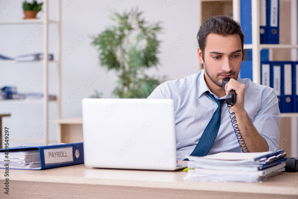 Young male bookkeeper working in the office Young male bookkeeper working in the office