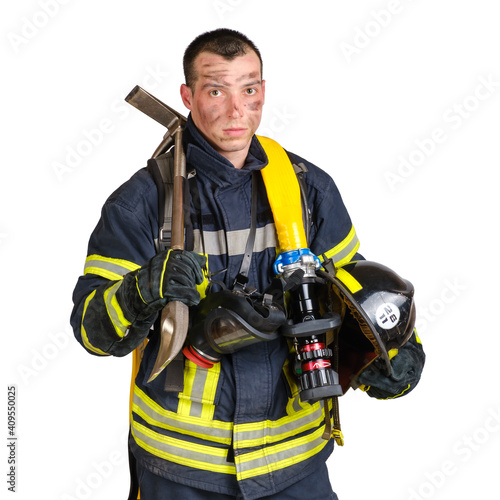 Young brave man in uniform of firefighter holds hardhat, pinch bar, fire hose and looking at camera isolated on white background