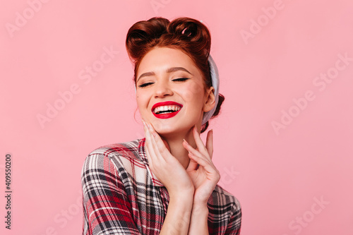 Excited caucasian woman in checkered shirt expressing happiness. Studio shot of laughing ginger girl isolated on pink background. © Look!