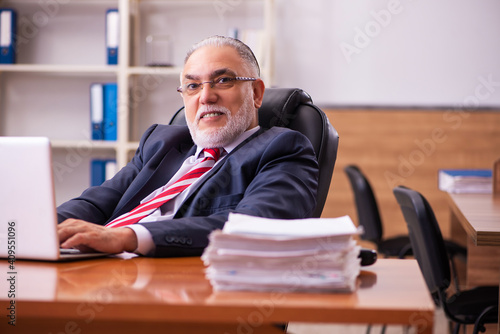 Old male employee sitting in the office