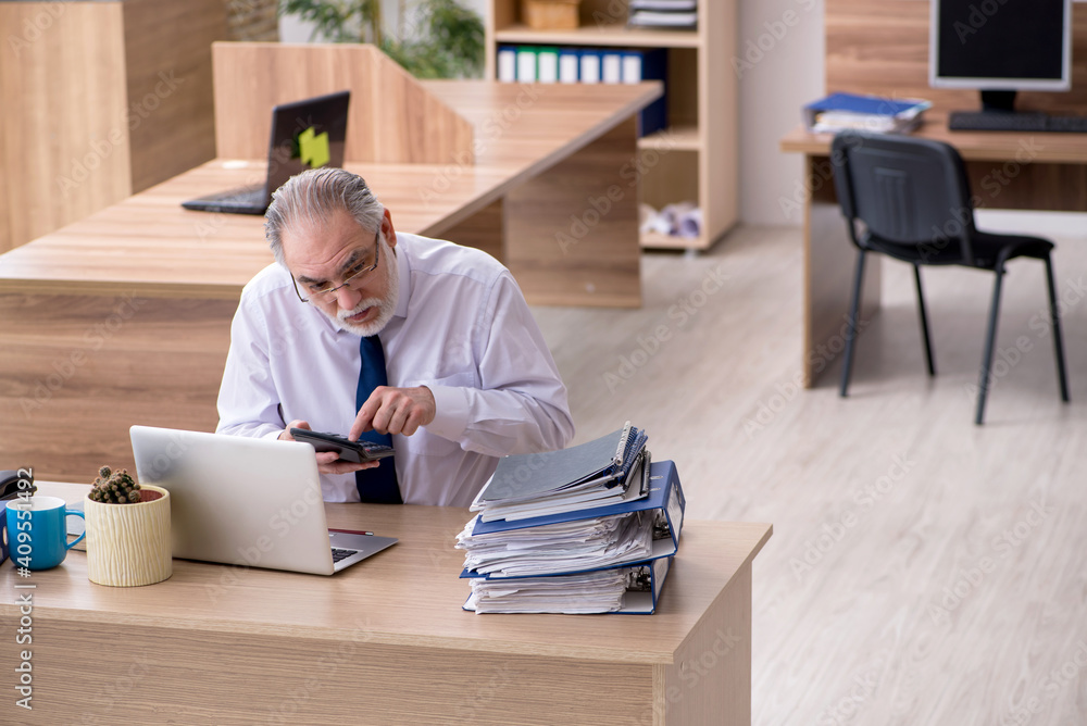 Old male employee working in the office Old male employee working in the office