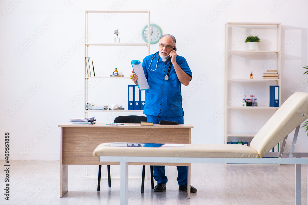 Old male doctor working in the clinic Old male doctor working in the clinic