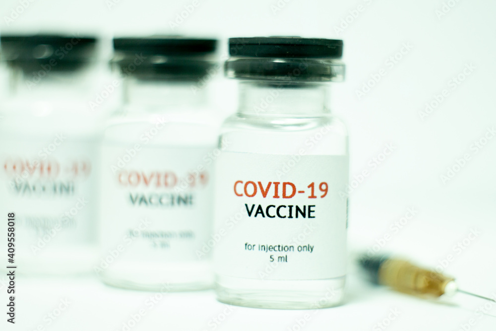 vials of covid-19 vaccine in a row with syringe vials of covid-19 vaccine in a row with syringe