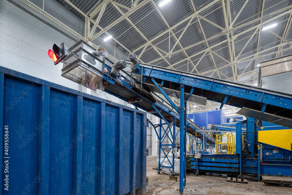 Waste sorting and recycling plant. Garbage from a conveyor is discharged into a large container