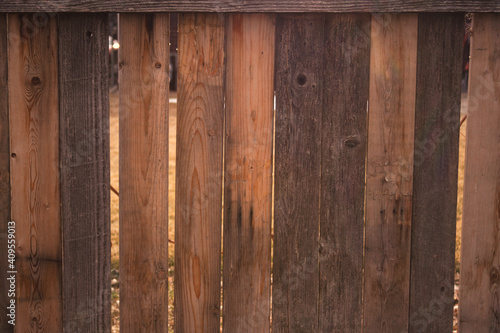 A weathered wooden fence has faded and taken on different shades of brown. 