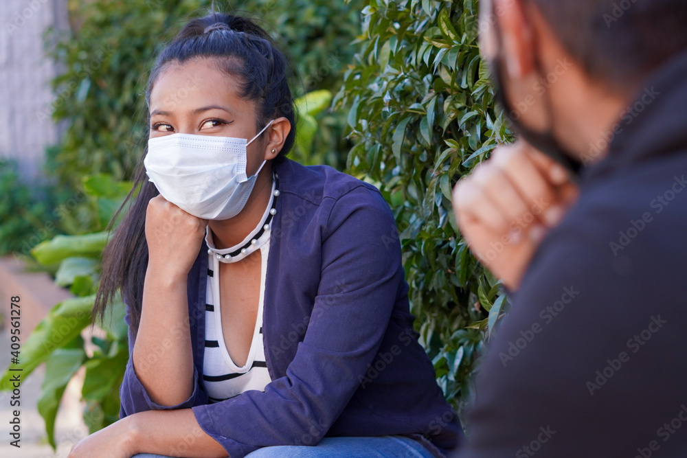 Portrait of a young woman with a mask calling her friends by video call, showing prevention, looking at the camera and protecting herself from covid 19 or coronavirus Portrait of a young woman with a mask calling her friends by video call, showing prevention, looking at the camera and protecting herself from covid 19 or coronavirus