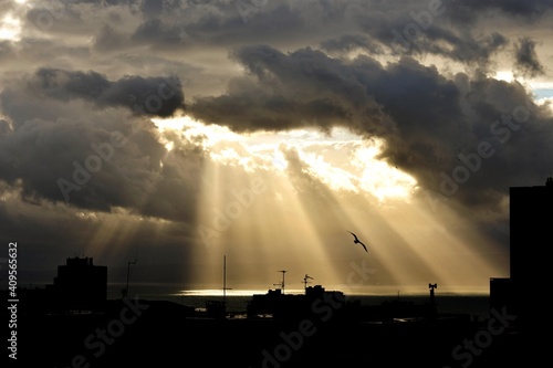Beautiful threatening dramatic sky with dark clouds and rays of summer sun/ Conceptual image of hope and light 