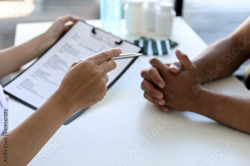 The doctor is explaining the treatment after examining the patient. Talk to the patient and check the information on the physical examination papers. Disease treatment concept.