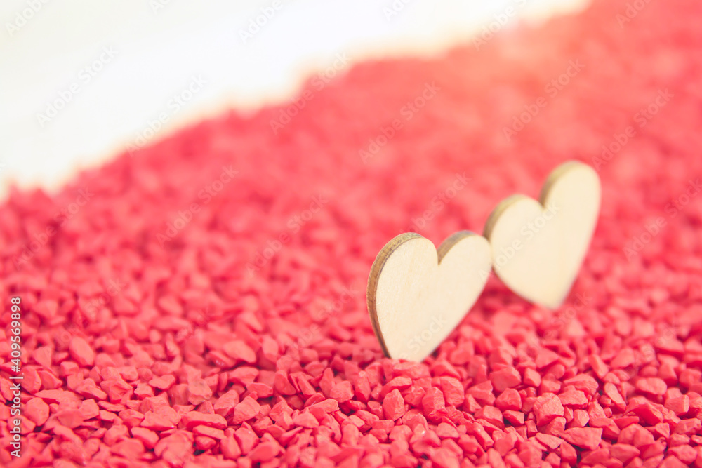 Fototapeta premium Close-up two hearts for love symbol on a red sand background. Concept the day of love 14 February happy valentine's day.
