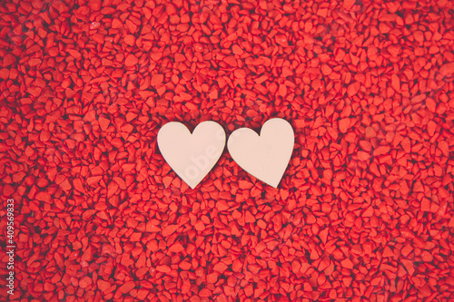 Close-up two hearts for love symbol on a red sand background. Concept the day of love 14 February happy valentine s day.