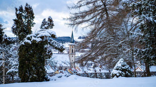 The beautiful church in the small town of Löffingen on a snowy winter day peeking through trees