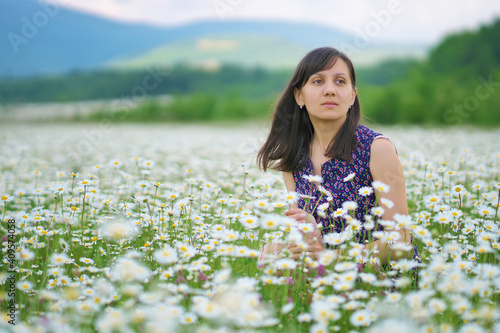 Young woman in chamomile meadow.