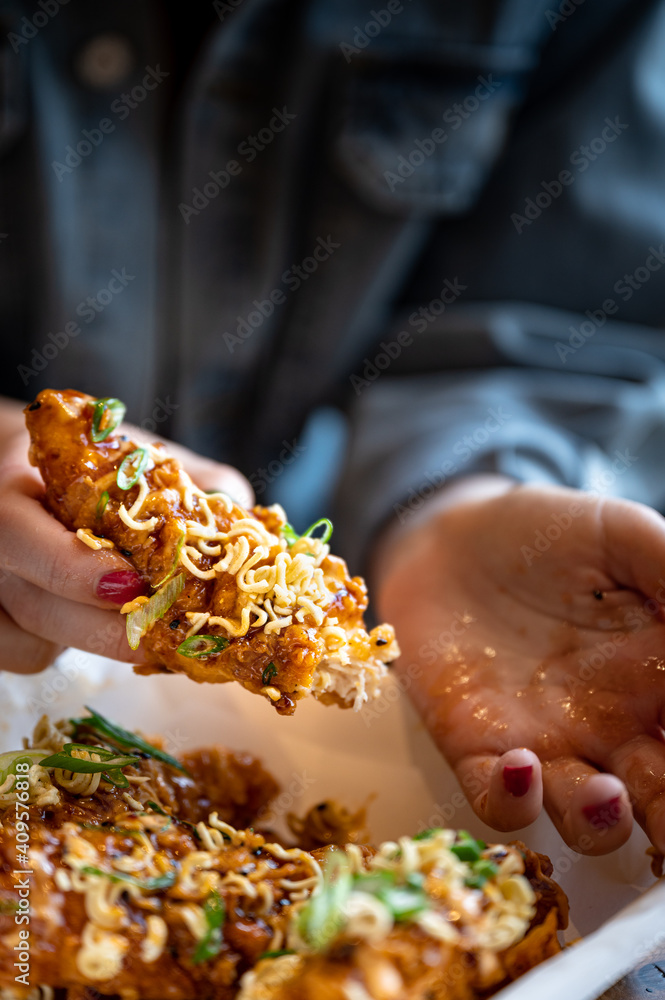 Korean fried chicken tender with hands holding