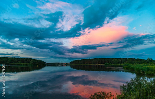 Sunset light in the sky over the lake in the East in summer © Александр Коликов
