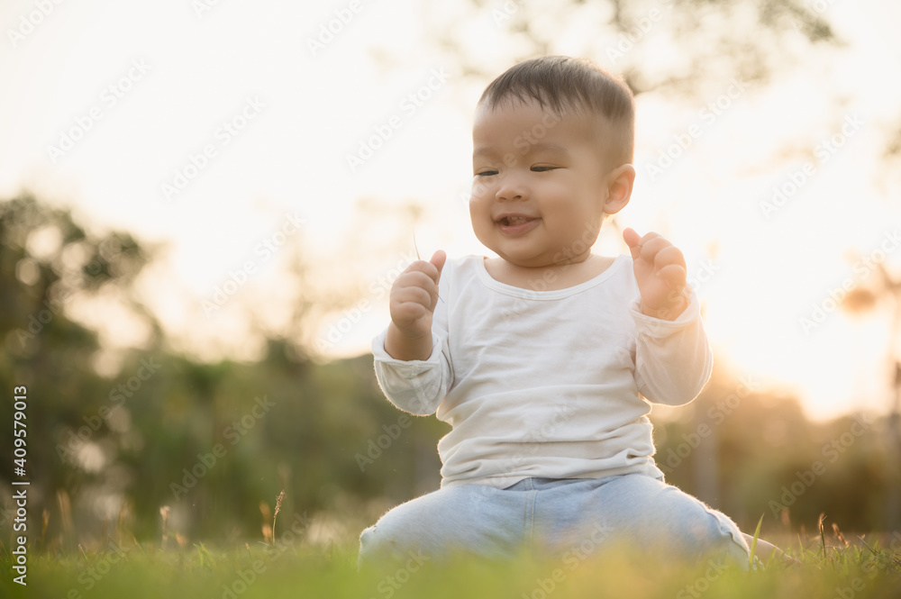 Happy child,kid or boy sitting on the ground in the outdoor park. Happy child,kid or boy sitting on the ground in the outdoor park.