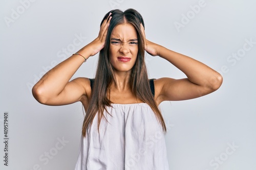 Young hispanic woman wearing casual clothes suffering from headache desperate and stressed because pain and migraine. hands on head.