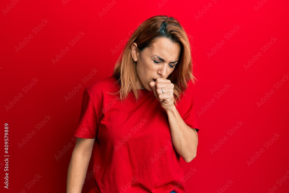 Hispanic young woman wearing casual red t shirt feeling unwell and coughing as symptom for cold or bronchitis. health care concept. Hispanic young woman wearing casual red t shirt feeling unwell and coughing as symptom for cold or bronchitis. health care concept.