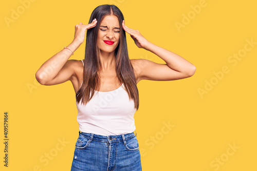 Young hispanic woman wearing casual clothes suffering from headache desperate and stressed because pain and migraine. hands on head.