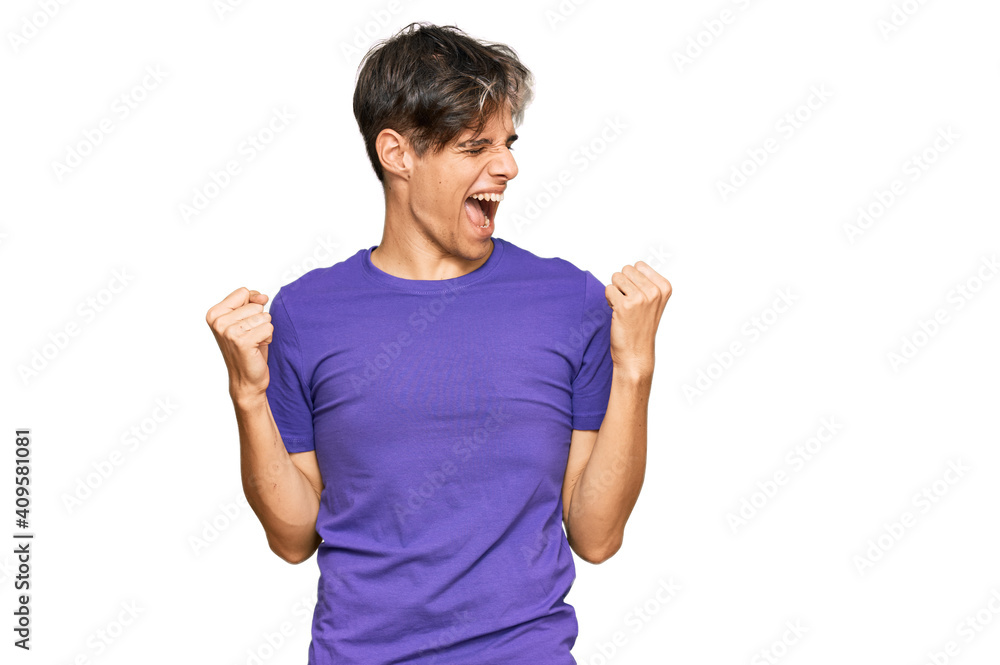 Young hispanic man wearing casual clothes very happy and excited doing winner gesture with arms raised, smiling and screaming for success. celebration concept. Young hispanic man wearing casual clothes very happy and excited doing winner gesture with arms raised, smiling and screaming for success. celebration concept.