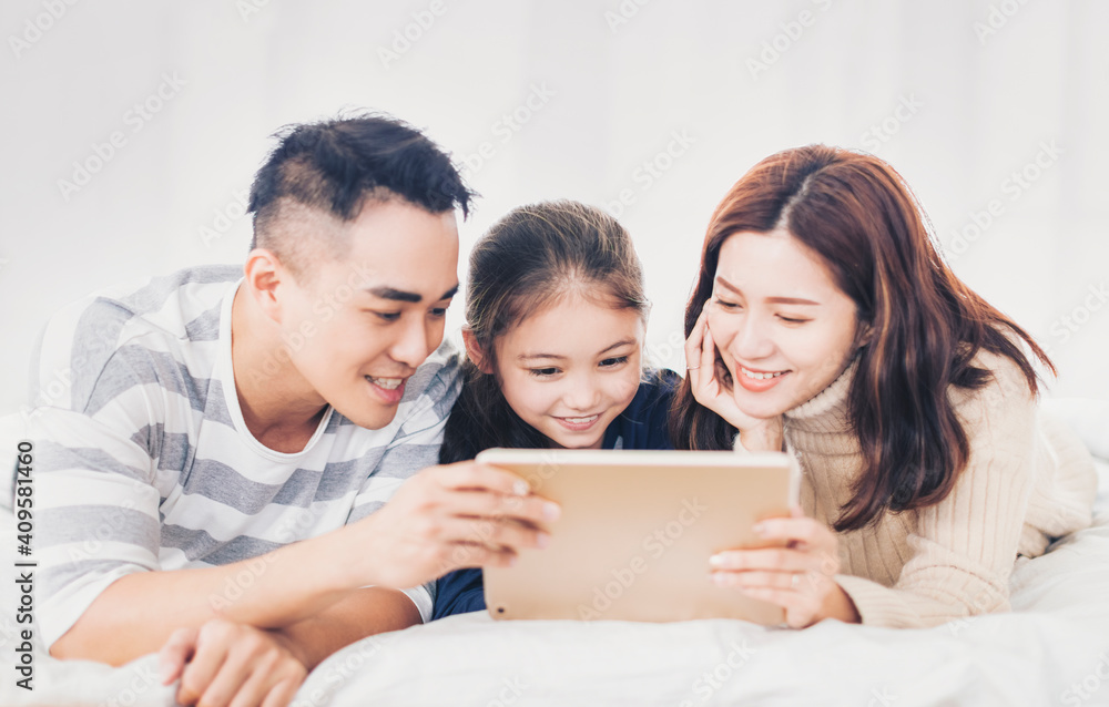 happy family watching the digital tablet in bed happy family watching the digital tablet in bed