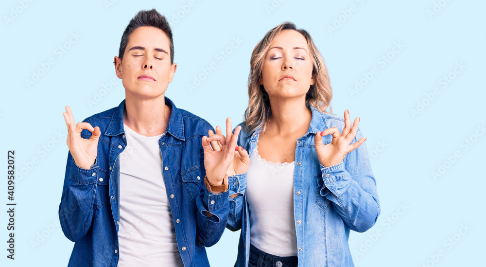 Couple of women wearing casual clothes relaxed and smiling with eyes closed doing meditation gesture with fingers. yoga concept. Couple of women wearing casual clothes relaxed and smiling with eyes closed doing meditation gesture with fingers. yoga concept.