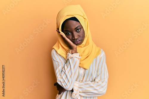 Beautiful african young woman wearing traditional islamic hijab scarf thinking looking tired and bored with depression problems with crossed arms. © Krakenimages.com
