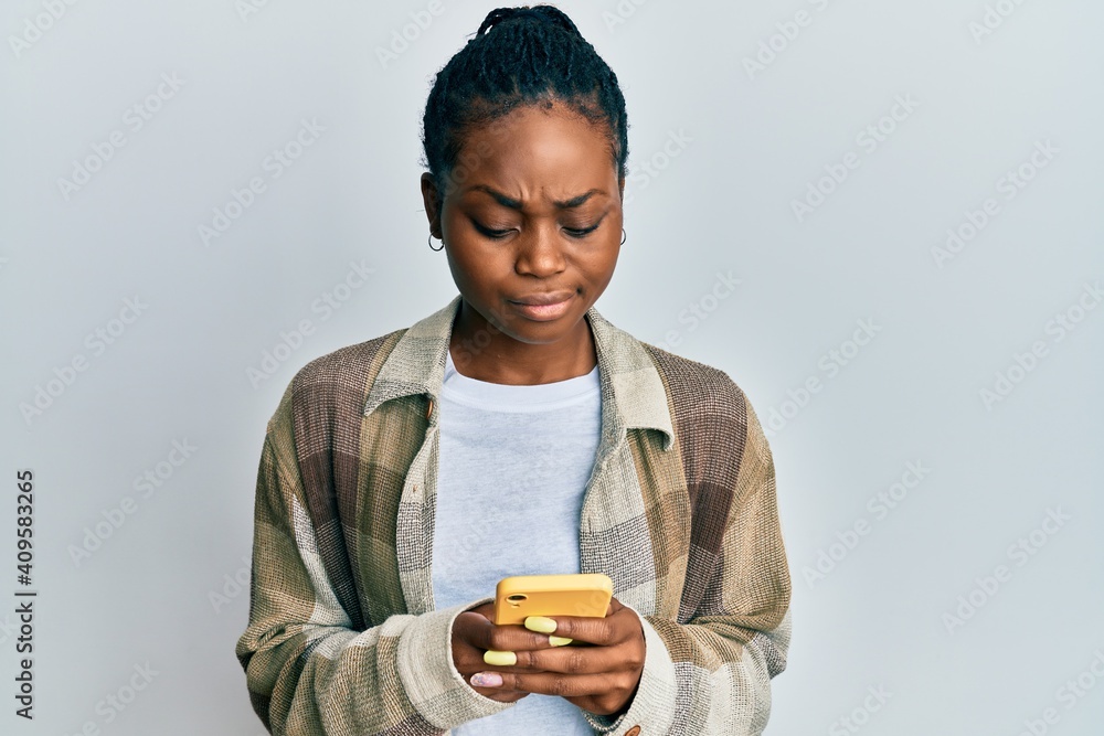Young african american woman using smartphone skeptic and nervous, frowning upset because of problem. negative person. Young african american woman using smartphone skeptic and nervous, frowning upset because of problem. negative person.