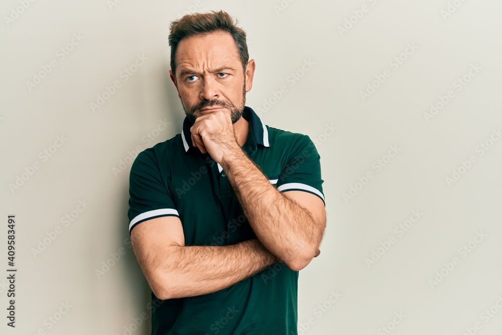 Middle age man wearing casual clothes thinking concentrated about doubt with finger on chin and looking up wondering Middle age man wearing casual clothes thinking concentrated about doubt with finger on chin and looking up wondering
