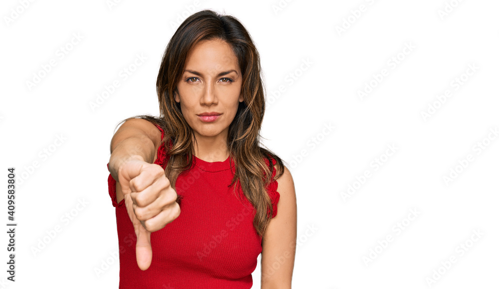 Young hispanic woman wearing casual clothes looking unhappy and angry showing rejection and negative with thumbs down gesture. bad expression. Young hispanic woman wearing casual clothes looking unhappy and angry showing rejection and negative with thumbs down gesture. bad expression.
