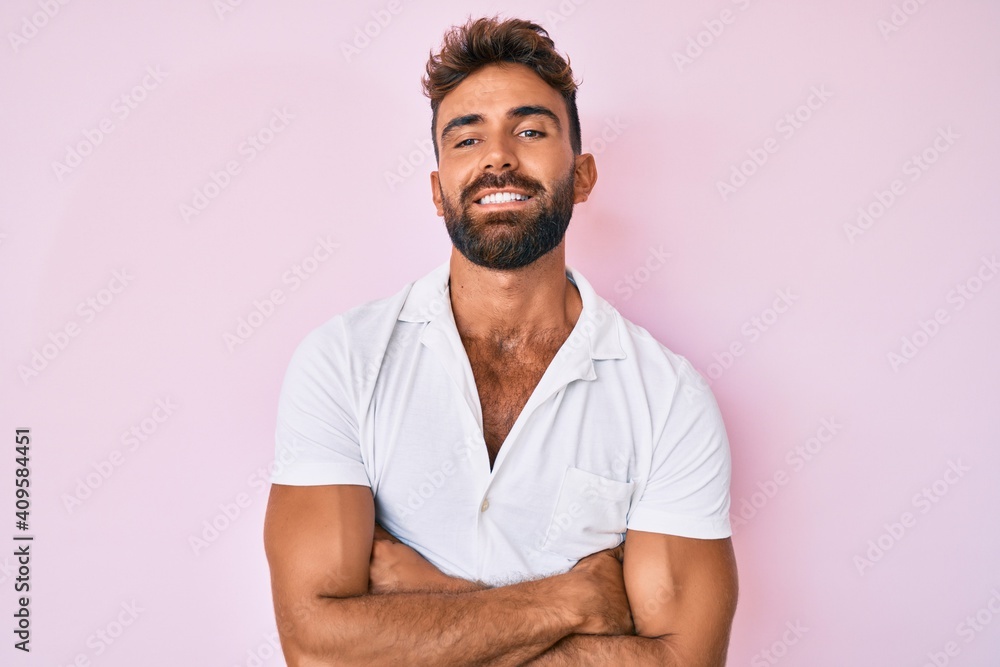 Young hispanic man wearing casual clothes happy face smiling with crossed arms looking at the camera. positive person. Young hispanic man wearing casual clothes happy face smiling with crossed arms looking at the camera. positive person.