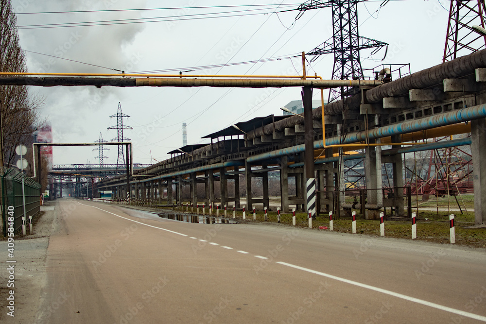 Naklejka premium a road in an industrial area. pipes along the road. power lines. High quality photo