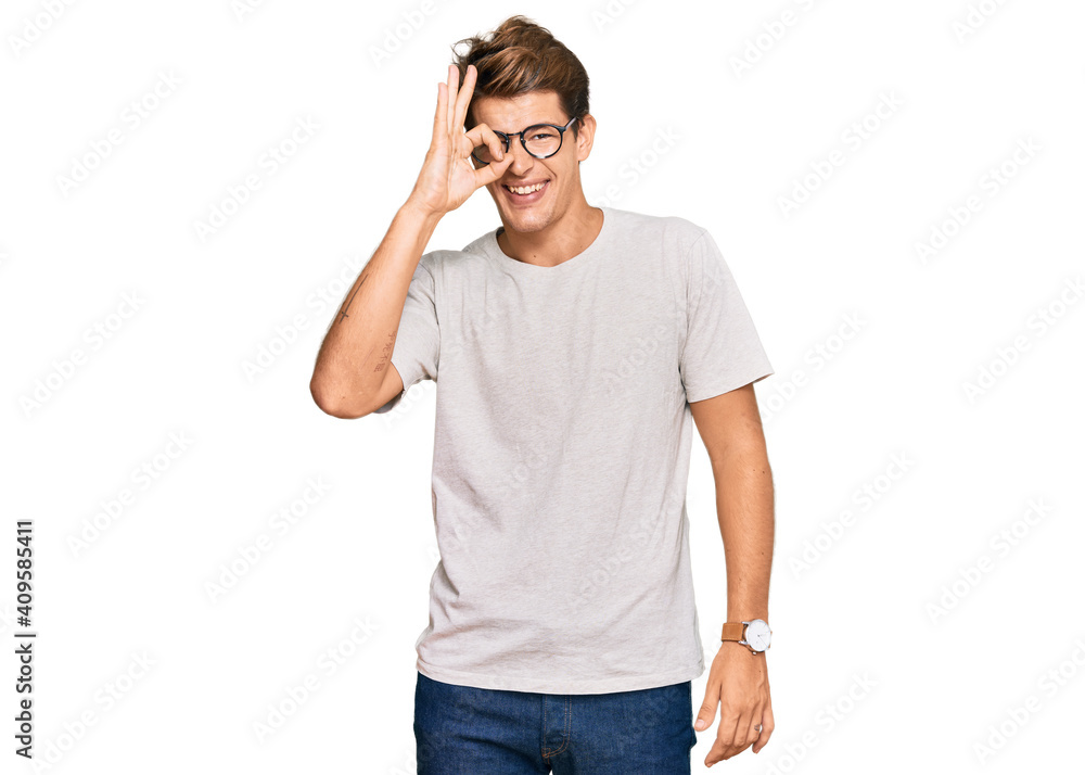 Handsome caucasian man wearing casual clothes and glasses doing ok gesture with hand smiling, eye looking through fingers with happy face.
